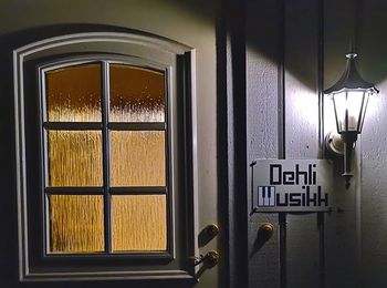Sign with Dehli Musikk logo on house wall