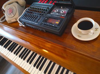 Louis Zwicki Pianette with an old telephone, tape recorder and coffee cup on top