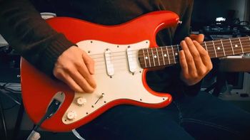 A red Fender Stratocaster being played
