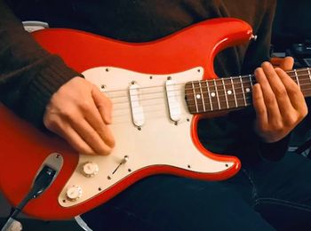 A red Fender Stratocaster being played